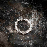14K white gold twisted seam ring on dark reflective surface, front view of braided hoop design