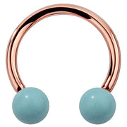 14K rose gold circular barbell with synthetic turquoise ball ends, warm-toned front view