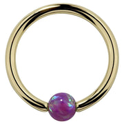 14K yellow gold captive bead ring with purple opal bead, front view on white background