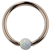 14K rose gold captive bead ring with white opal ball, front view showing warm pink-gold tone