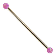 14k yellow gold industrial barbell with purple synthetic opal ball ends, front view on white background