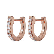 Pair of 14k rose gold 10mm diamond huggie hoop earrings with prong-set diamonds, angled view