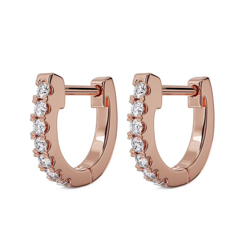 Pair of 14k rose gold 10mm diamond huggie hoop earrings with prong-set diamonds, angled view
