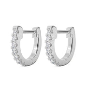 Pair of 14k white gold 10mm diamond huggie hoops with prong-set diamonds, angled view