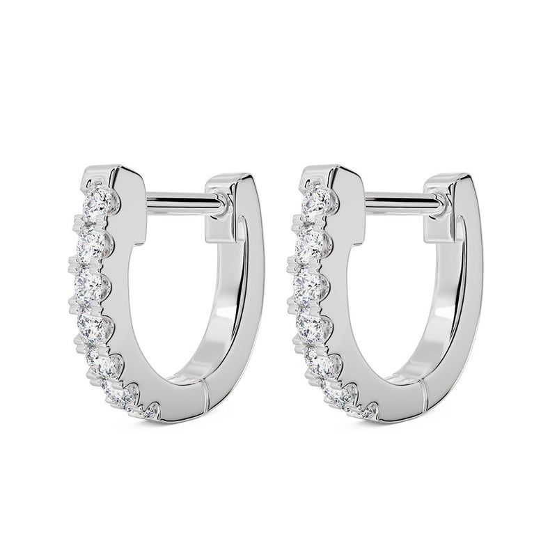 Pair of 14k white gold 10mm diamond huggie hoops with prong-set diamonds, angled view