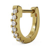 Close-up angled view of single 14k yellow gold huggie hoop highlighting diamond prong setting