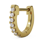 Close-up angled view of single 14k yellow gold huggie hoop highlighting diamond prong setting