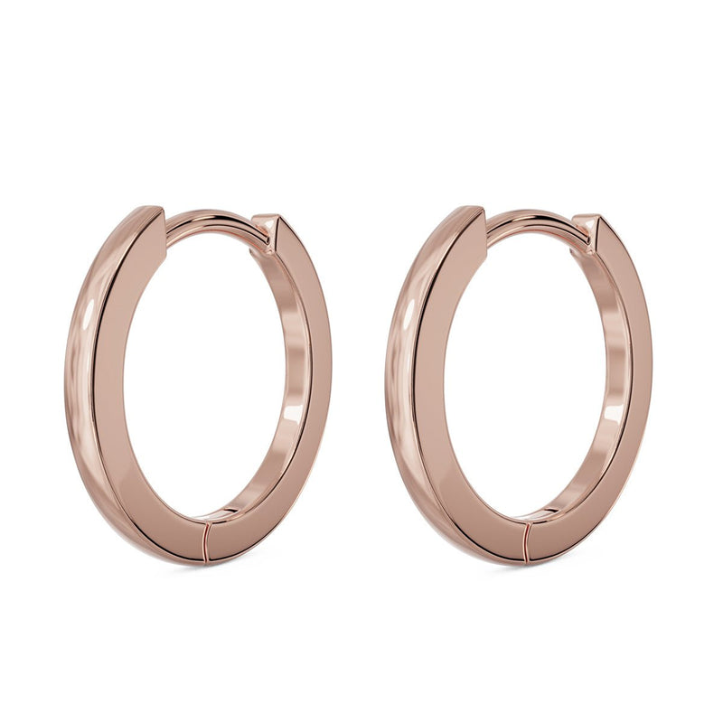 14k rose gold huggie hoop earrings, pair shown at an angle with warm blush-tone polish