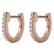 Pair of 14k rose gold diamond huggie hoop earrings, angled view showing hinged clasp and diamond row