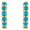Close-up front view of paired 14k yellow gold huggie hoops showing turquoise cabochon stone detail