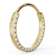Angled side profile of large 14k yellow gold pearl clicker hoop showing ring thickness and pearl row