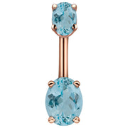 14k rose gold belly ring with dual light blue oval CZ stones in four-prong settings, front view