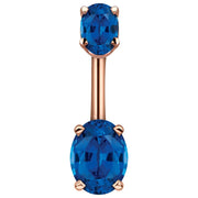 14k rose gold belly ring with dual deep blue oval CZ stones in four-prong settings, front view