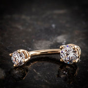 14k rose gold double CZ navel ring with clear gems, angled lifestyle shot on dark marble surface
