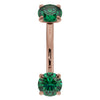Close-up front view of 14K rose gold emerald curved barbell highlighting larger 14G stone size