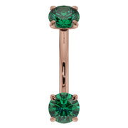 Close-up front view of 14K rose gold emerald curved barbell highlighting larger 14G stone size
