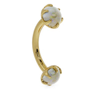Side profile of 14k yellow gold opal curved barbell showing banana curve and prong settings