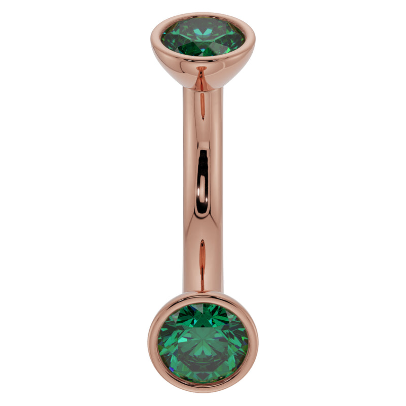 14k rose gold 14G emerald bezel curved barbell, angled view highlighting warm tone and green stones