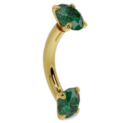 14k yellow gold emerald curved barbell angled view highlighting the banana curve and dual emerald prongs
