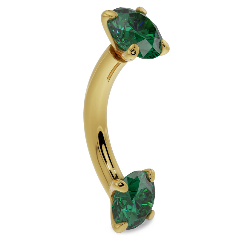 14k yellow gold emerald curved barbell angled view highlighting the banana curve and dual emerald prongs