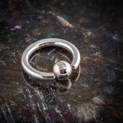 14K white gold fixed bead ring on dark marble surface, angled view highlighting bead closure