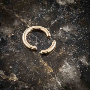 14K yellow gold segment ring open on dark marble surface, showing removable segment detail