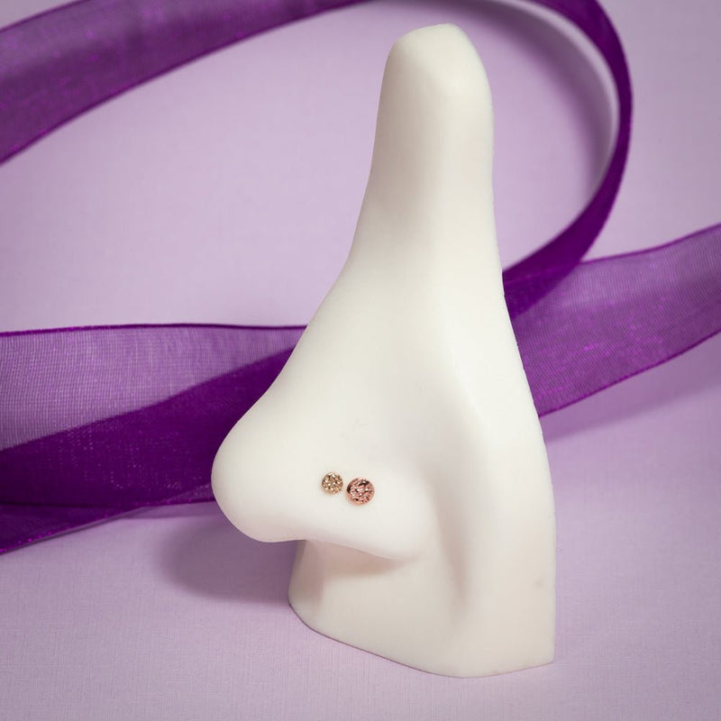 14k rose gold hammered disc flat back studs shown on nose mannequin for fit and size reference