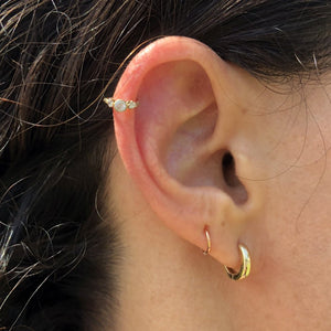 14k gold three-CZ clicker ring worn in helix piercing on model, showing snug fit and sparkle