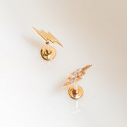 Two 14k gold lightning bolt flat back studs side by side — plain and CZ-set versions compared for style