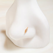 14k yellow gold diamond pavé lightning bolt flat back stud shown on nose piercing display for fit