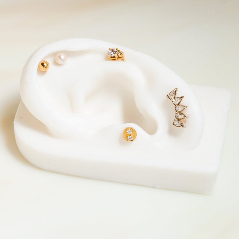 White sapphire 5-pear crescent flat back stud on ceramic ear display, shown in lower helix placement