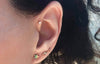 Gold crescent moon diamond pave stud worn in second lobe piercing alongside star and lightning bolt studs
