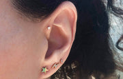 Gold crescent moon diamond pave stud worn in second lobe piercing alongside star and lightning bolt studs