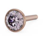 Angled close-up of 3mm pink diamond in 14k rose gold bezel nose stud, straight post visible