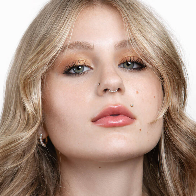 Diamond bezel flat back stud in medusa piercing shown from a slightly lower angle, full face portrait