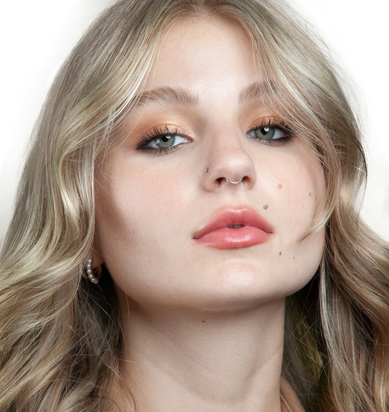 Model wearing 2mm diamond bezel flat back stud as a lip piercing, front face portrait shot