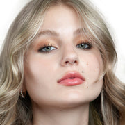 14k white gold CZ flat back stud worn as a labret piercing on female model, front-facing portrait