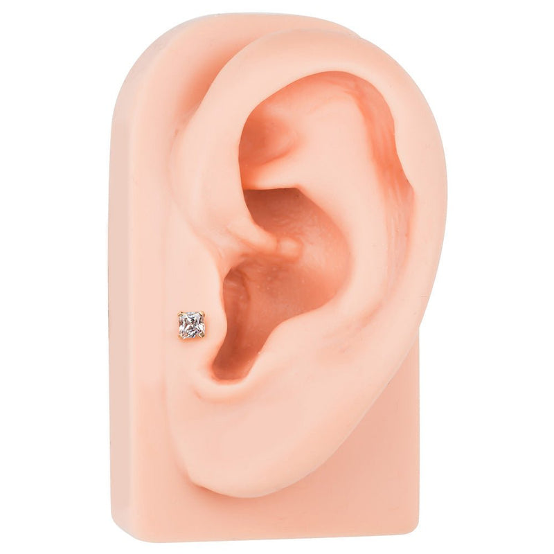 Square CZ 14K gold labret shown in tragus piercing on silicone ear model, side angle