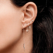 Diamond bezel stud in upper lobe piercing styled with rose gold charm hoops, ear stack lifestyle shot