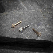 14k gold CZ straight post nose studs in yellow and white gold on slate, showing pin post style variety