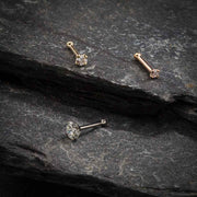 CZ nose bone and straight post styles in yellow, white, and rose gold on dark stone
