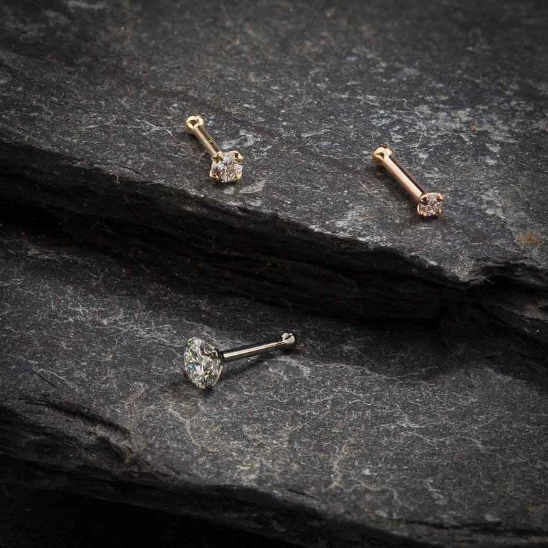 CZ nose bone and straight post styles in yellow, white, and rose gold on dark stone