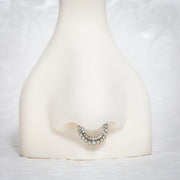 Opal and diamond moon clicker hoop shown in a septum piercing on a nose mannequin for fit reference