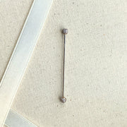 Diamond pavé straight barbell shown on linen fabric for size reference, full length visible