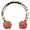 14k yellow gold circular barbell with pink opal balls, front view showing iridescent swirl detail