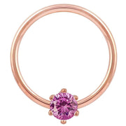 Close-up front view of 14k rose gold captive ring highlighting pink CZ prong setting and band finish