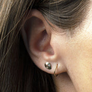 14K gold alien diamond flat back earring worn in a lobe piercing alongside a gold hoop