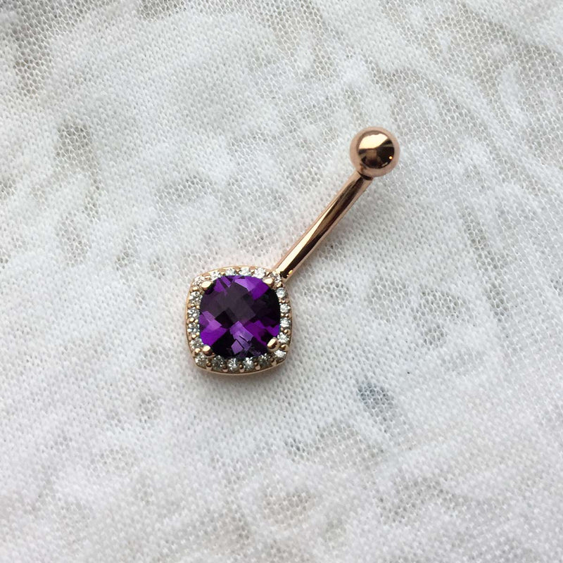 14k rose gold amethyst and diamond cushion-cut navel ring laid on fabric for size reference