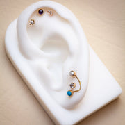 Amethyst cabochon flat back stud styled in upper cartilage piercing on white ear display