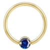 14k yellow gold fixed bead ring with blue CZ bezel, angled front view showing stone detail